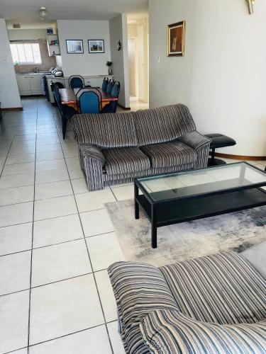 uma sala de estar com dois sofás e uma mesa de centro em Sea View Heights em Amanzimtoti