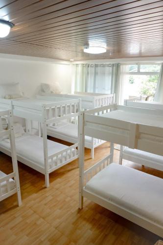 Casisang的住宿－Malaybalay Air'bnb Travellers Inn，一间设有几张白色双层床的房间