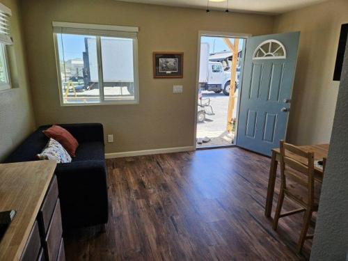 a living room with a couch and a blue door at Tiny Cabin #19 American Trails in Quartzsite