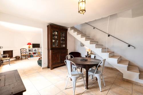 une salle à manger avec une table et un escalier dans l'établissement Bergerie Piattone - Maison avec grand jardin, à Pianottoli-Caldarello