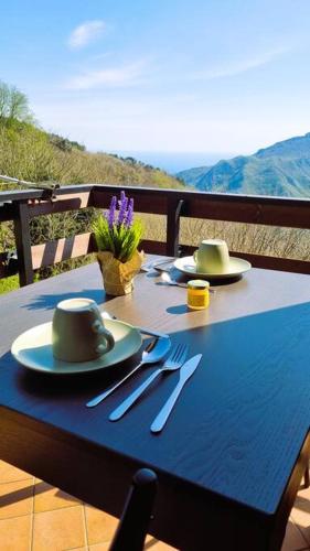 a blue table with plates and utensils on a table at Bee Freeride Biker house in Magliolo