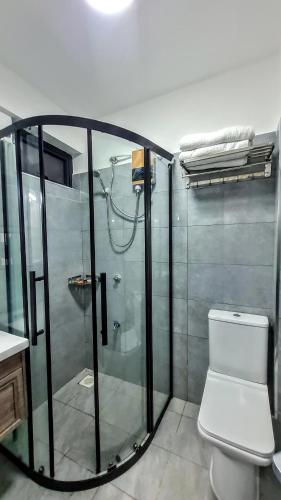 y baño con ducha de cristal y aseo. en Rads apartment,kileleshwa, en Nairobi