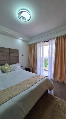 1 dormitorio con cama grande y ventana grande en Rads apartment,kileleshwa, en Nairobi