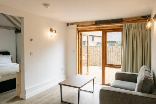 a living room with a bed and a couch and a table at 3 Henham Barns in Beccles