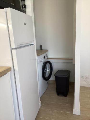 une cuisine avec un réfrigérateur et une machine à laver dans l'établissement Les Embruns Appart 1ere ligne Carnon parking gratuit, à Mauguio