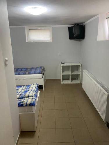Habitación con 2 camas y TV. en Hostel Chodecz, en Chodecz
