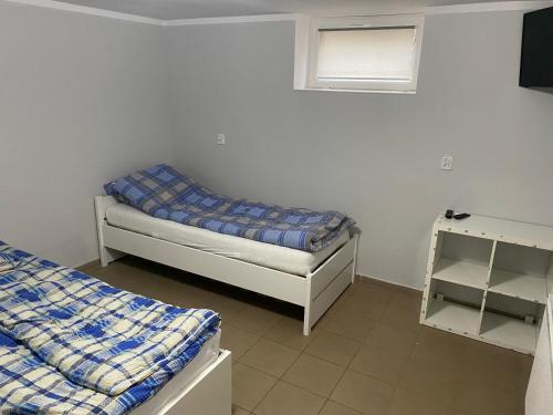 - une petite chambre avec 2 lits et une fenêtre dans l'établissement Hostel Chodecz, à Chodecz
