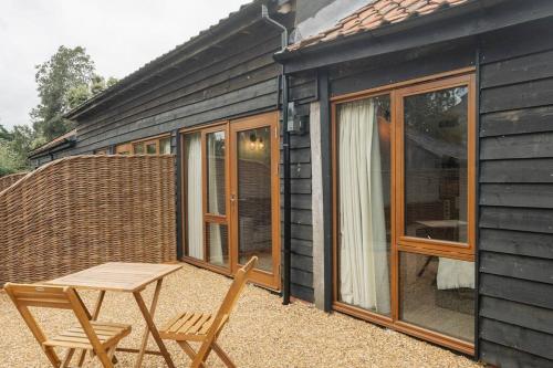 a picnic table and chairs in front of a house at 3 Henham Barns in Beccles