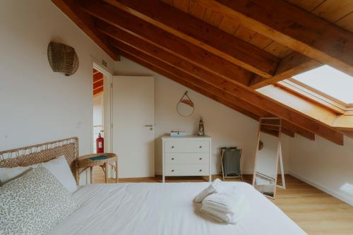 ein Schlafzimmer mit einem weißen Bett und Holzdecken in der Unterkunft Best Houses 17 - Casa da Saudade in Atouguia da Baleia