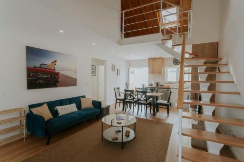 a living room with a blue couch and a spiral staircase at Best Houses 17 - Casa da Saudade in Atouguia da Baleia
