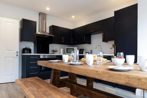 uma cozinha com uma mesa de madeira e armários pretos em The Nook em St Ives
