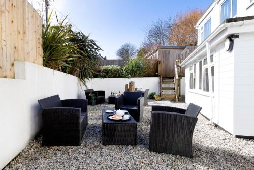 un patio con sillas, una mesa y una valla en The Nook en St Ives