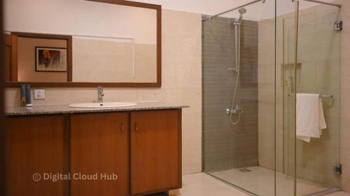 a bathroom with a sink and a shower at Ambassador Hotel Clifton in Karachi