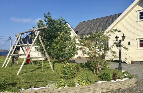 a swing set in a yard next to a house at Myranhaugen, house in Reine in Moskenes