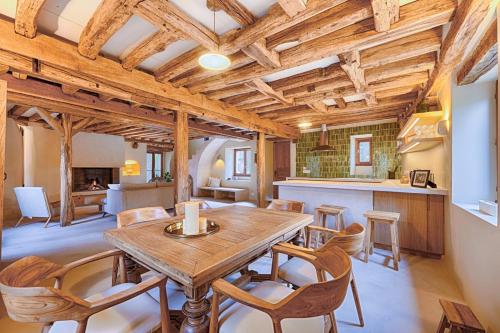 une cuisine et une salle à manger avec une table et des chaises en bois dans l'établissement Luxury Moulin de Rochopt, à Boussy-Saint-Antoine