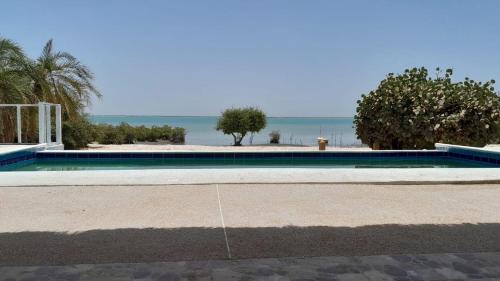 a swimming pool with the ocean in the background at la villa sur la plage in Palmarin