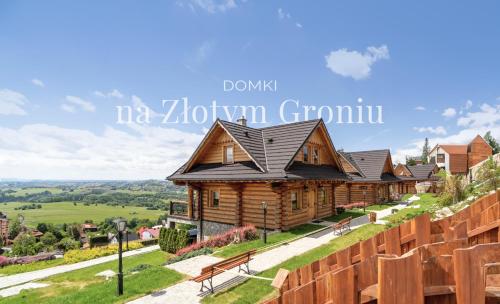 a log house on a hill with a fence at Domki Na Złotym Groniu in Istebna