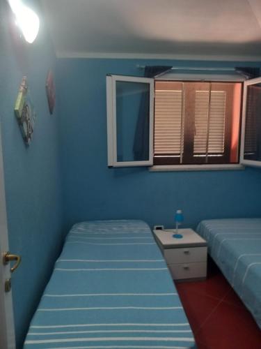 a small bedroom with two beds and a window at ZIRICHELTULA Villa PANORAMICA con ARIA CONDIZIONATA in Lu Pultiddolu