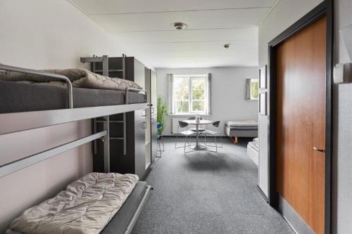 a room with two bunk beds and a table at Danhostel Esbjerg in Esbjerg