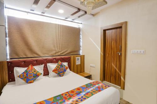 a bedroom with a large bed with a wooden headboard at FabExpress P2 in Bhopal