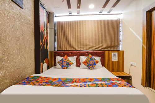 a bedroom with a bed with colorful pillows at FabExpress P2 in Bhopal