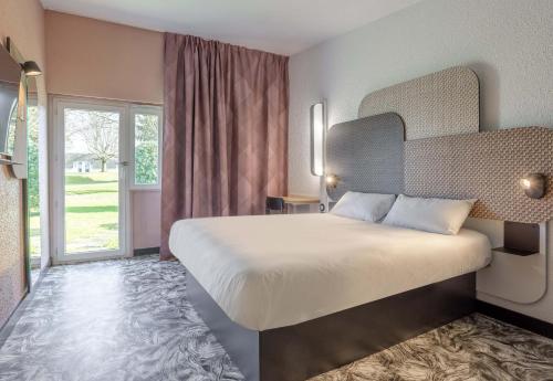ヴァランシエンヌにあるB&B HOTEL Valenciennes Sudのベッドルーム(大型ベッド1台、大きな窓付)