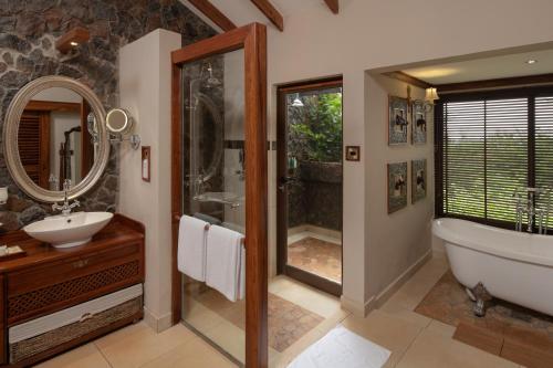 a bathroom with a tub and a shower and a sink at Ngorongoro Oldeani Mountain Lodge in Oldeani