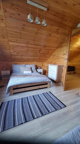 - une chambre avec un lit dans une cabane en bois dans l'établissement Sajzy Ostoja - domek nad jeziorem, à Sajzy