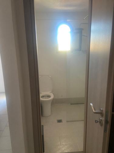 a bathroom with a toilet and a light on the wall at Молон Лаве in Nea Roda