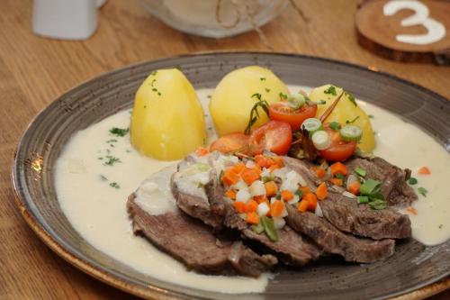 a plate of food with meat and vegetables on a table at Deutsches Haus Hotel Restaurant Gastwirtschaft Biergarten am Radweg Bermuthshain in Bermuthshain