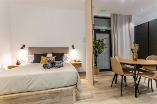 une chambre avec un lit, une table et des chaises dans l'établissement Suite Deluxe Valencia - AIORA Apartments, à Valence