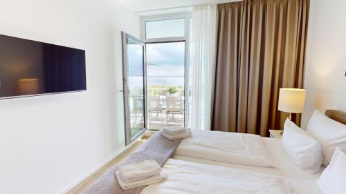 a hotel room with a bed and a large window at Südkap G-06 in Pelzerhaken