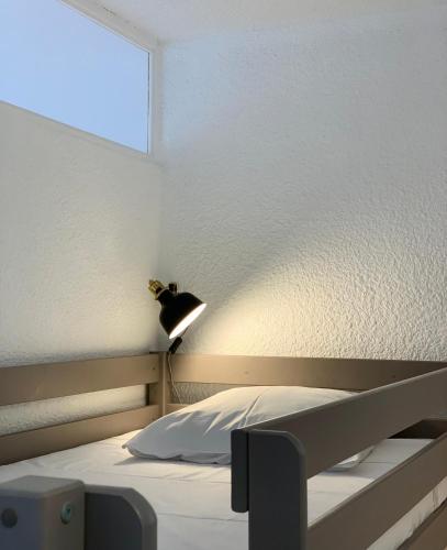 - une chambre avec un lit et une lampe sur le mur dans l'établissement Appartement moderne, mer à 50m, au Barcarès