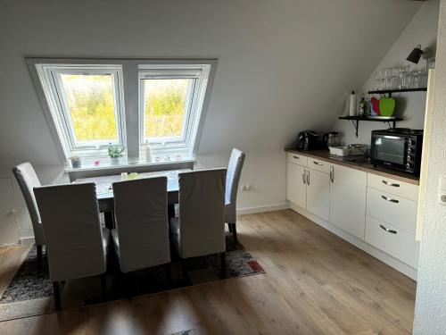 eine Küche mit einem Tisch mit Stühlen und einer Mikrowelle in der Unterkunft Galeriehaus in Münnerstadt