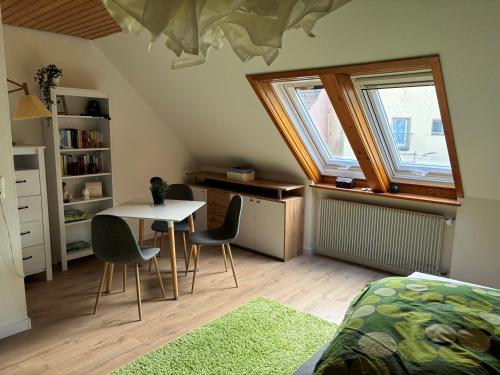 ein Zimmer mit einem Tisch und Stühlen im Dachgeschoss in der Unterkunft Galeriehaus in Münnerstadt