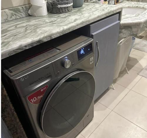 Una lavadora en una cocina debajo de un mostrador. en Cozy room, en El Cairo