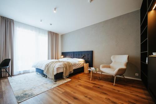 een slaapkamer met een bed en een stoel bij Apartmány Dog in Dock in Veselí nad Moravou