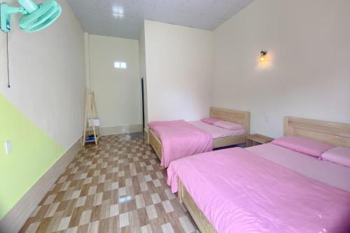 胡志明市的住宿－Mây Phú Quý，配有粉红色床单的客房内的两张床