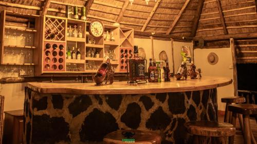 Embogo Safari Lodges في Katoke: بار مع كونتر خشبي في الغرفة