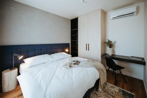 a bedroom with a large white bed and a desk at Apartmány Dog in Dock in Veselí nad Moravou