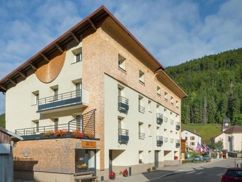 ein großes Gebäude mit Balkon auf der Seite in der Unterkunft Dvacances Résidence les tavaillons in Mijoux