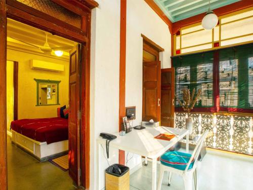 a room with a desk and a bed and a table at Mangaldas Ni Haveli II by The House of MG in Ahmedabad