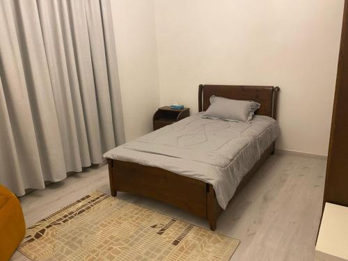 ein kleines Schlafzimmer mit einem Bett und Vorhängen in der Unterkunft Kinzo1 in Amman