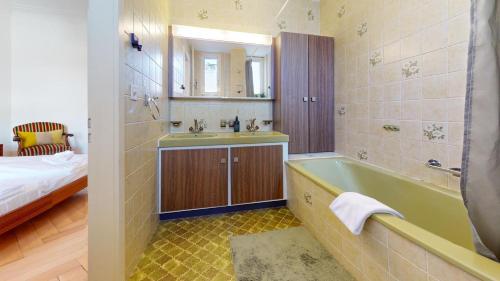 La salle de bains est pourvue d'une baignoire, d'un lavabo et d'un lit. dans l'établissement Unique Serviced Living @ Wettstein Turnerstrasse, à Bâle