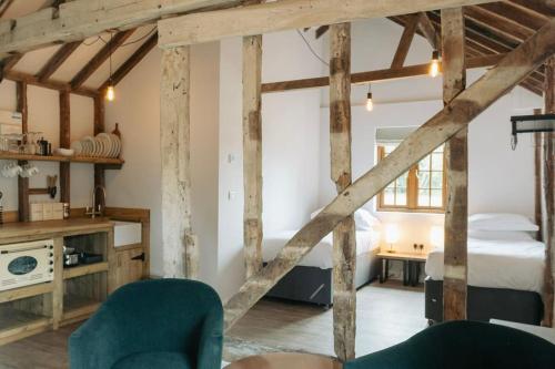 a room with a bedroom and a bed with wooden beams at 5 Henham Barns in Beccles
