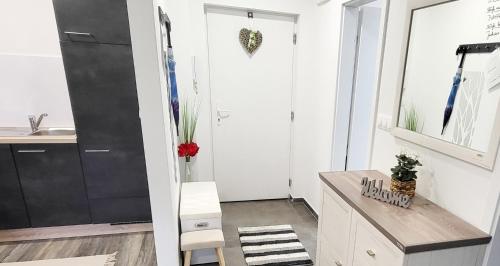 uma casa de banho com paredes brancas, um balcão e um lavatório. em Juhar 1 Apartman em Kőszeg