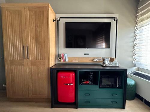 a room with a red refrigerator and a tv at Hotel Indigo Baton Rouge Downtown by IHG in Baton Rouge