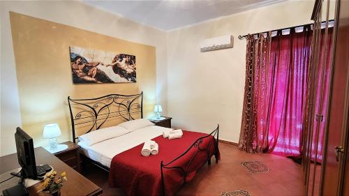 1 dormitorio con 1 cama con manta roja y mesa roja en Ruggero House, en Cefalú