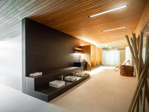 a bathroom with two sinks on a black wall at Sonne Mellau - Feel good Hotel in Mellau