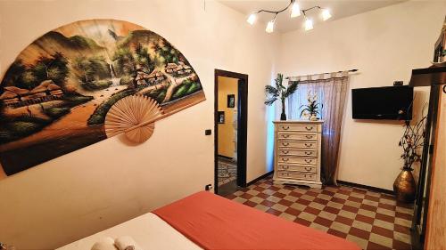 1 dormitorio con una gran pintura en la pared en Ruggero House, en Cefalú